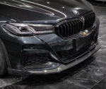 Close-up of a sleek black BMW front grille and headlights.