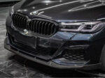 Close-up of a sleek black BMW front grille and headlights.