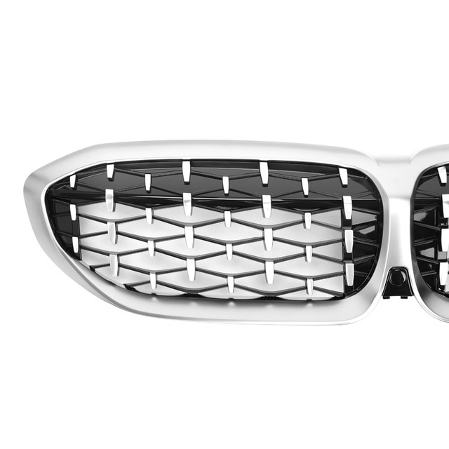 Close-up of a car's front grille with a geometric pattern.