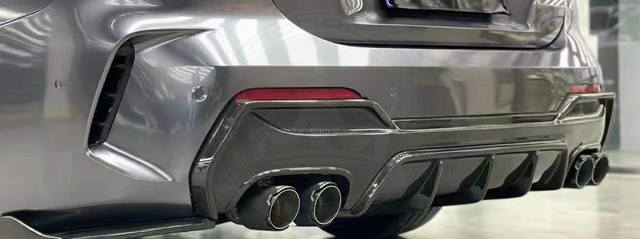 Close-up of a car's rear dual exhaust pipes and bumper details.
