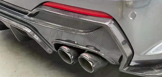 Close-up of dual exhaust pipes with carbon fiber detailing and red accents.