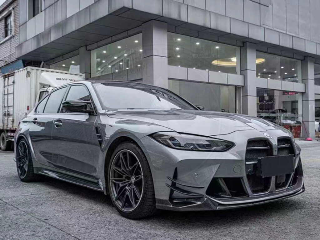 A sleek gray sports car parked outside a modern building on a rainy day.